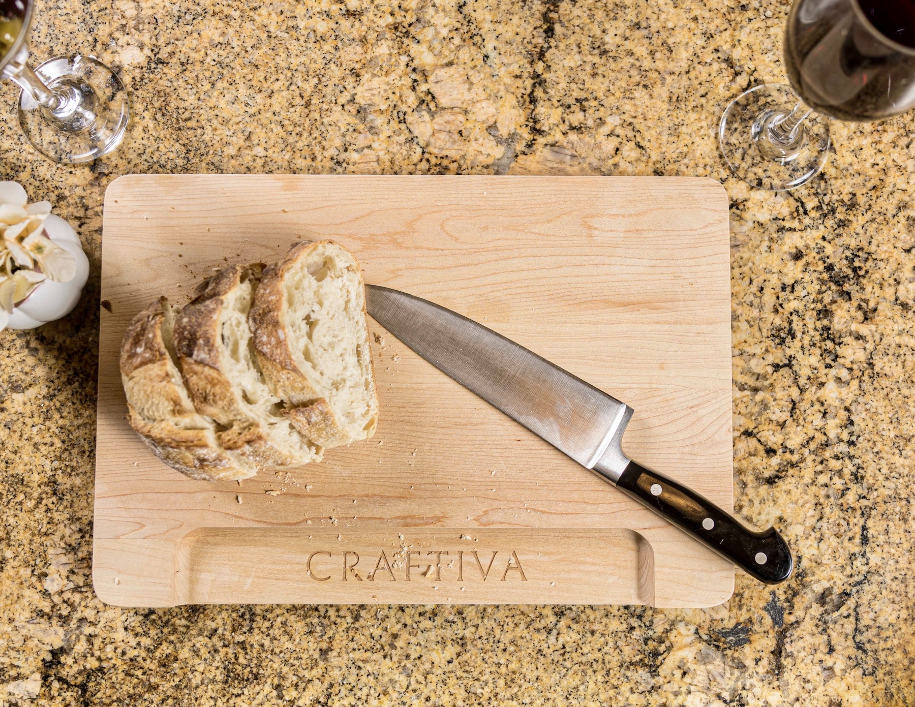 Solid maple cutting board in use with bread and a knife